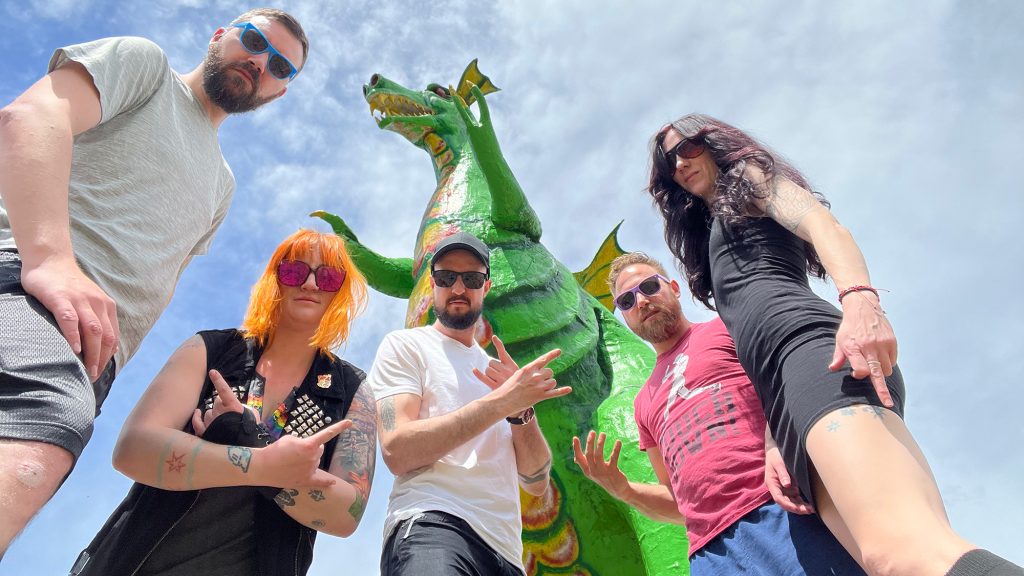 The Cancellations pose in front of a giant dragon statue